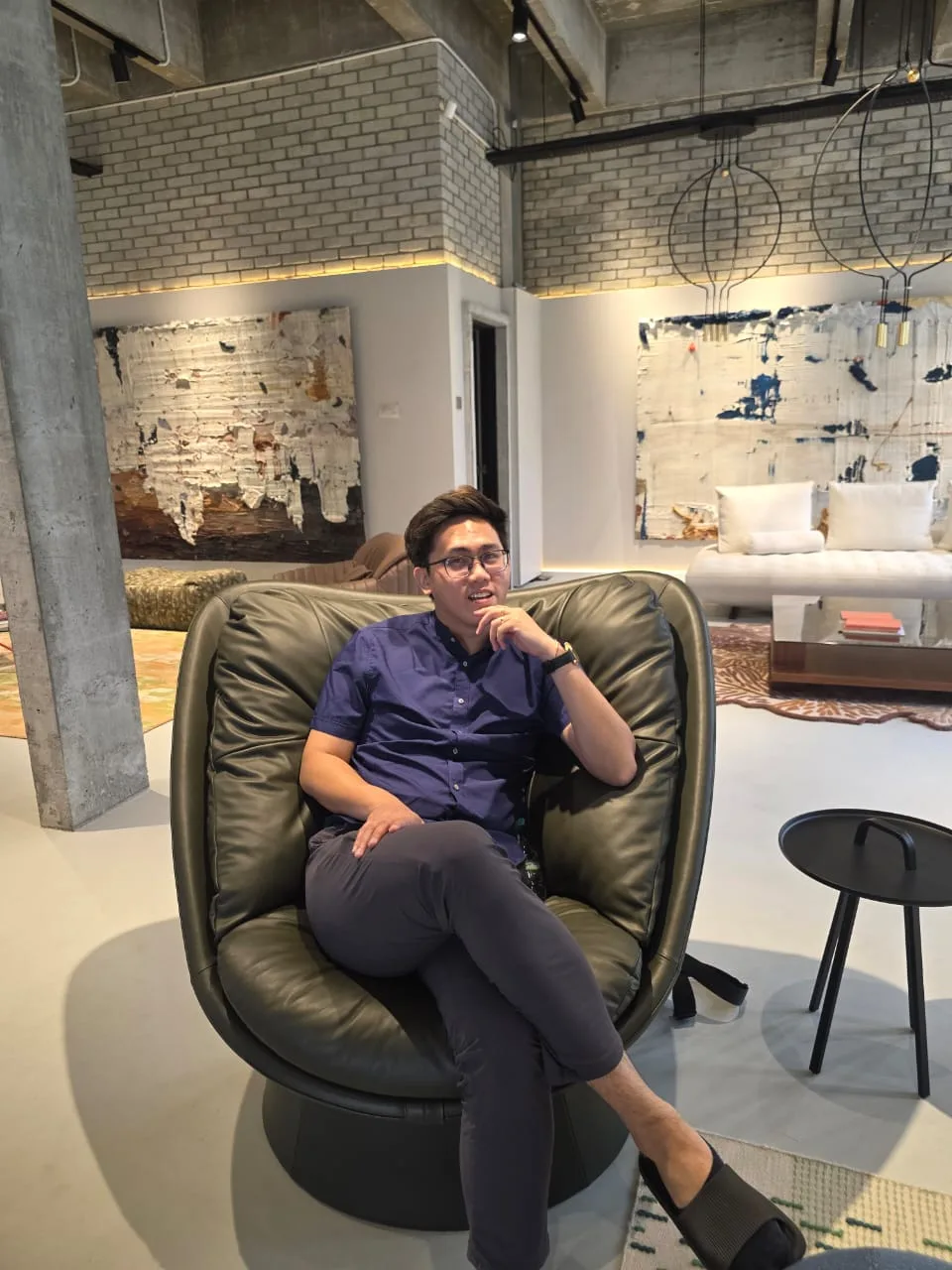 RENOssance founder seated in a leather lounge chair in a furniture showroom